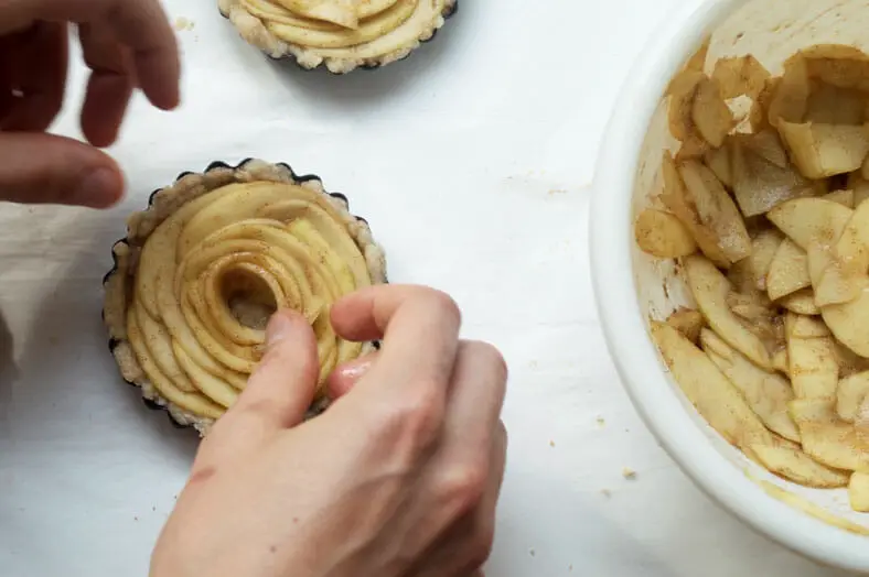 layering the thinly sliced apples and line them around the vegan apple pie crust