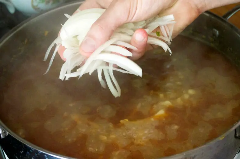 With only a few minutes to left before your mohinga (Burmese fish soup) is done, you'll want to add in some fresh onions to boil and soften