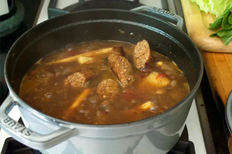 Then, for Pochero the Filipeno beef stew, cut the fried chorizo into slices, which will then be added to the beef stew consisting of tomatoes, onions, garlic and ginger
