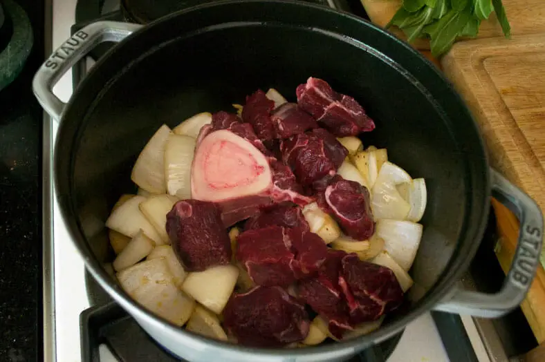 To make pochero, a Filipino pork stew, after you dry fry your chorizo, throw in your mashed garlic and ginger and chunks of onion and then add your beef