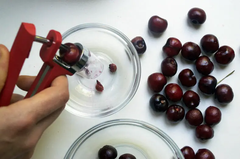 Pitting cherries for a French cherry tart clafoutis