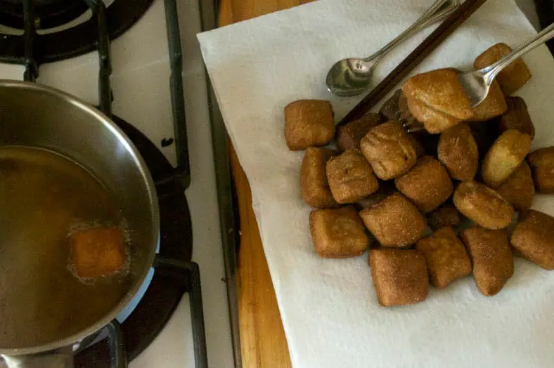After frying the fresh dough in coconut oil, set the fried dough onto a paper towel to remove excess oil