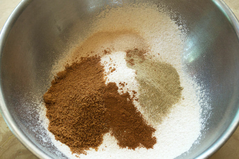 Mixing wheat flour, cinnamon, coconut sugar, cardamom, and salt to make Kenyan Cardamom Beignets or Doughnut