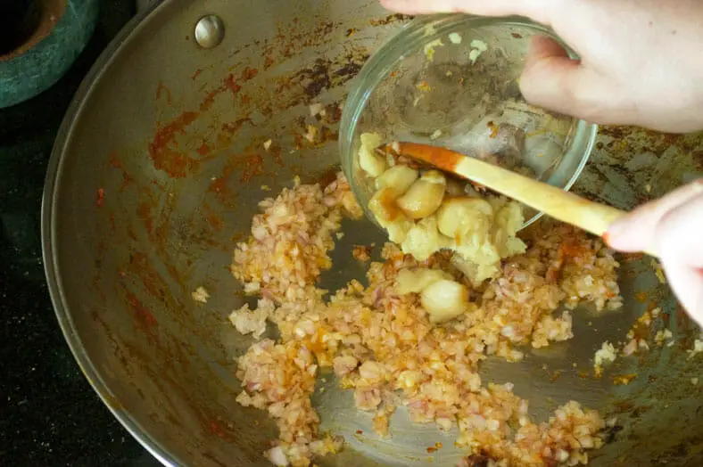 After putting the tomato sauce to the side, use the same pan to fry shallots and roasted garlic for Singapore's chili crab dish