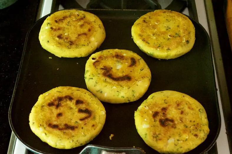 To make arepas rellenas, a Venezuelan corn cakes, shape the dough into small balls and then flatten them into discs and then pan fry them (no oil) until they start to brown