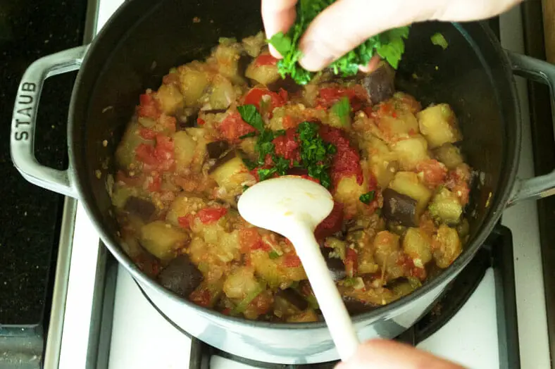 To make caponata, a classic Sicilian dish of stewed aubergines or eggplant, saute your eggplant until soft and then add garlic, shallots, red pepper, peeled and diced tomato, and parsley
