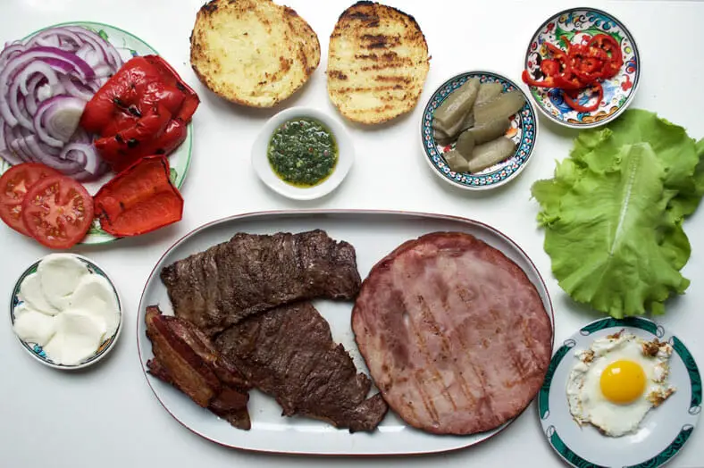 Here are all the prepared and grilled meats and other ingredients need to build the Uruguayan Chivito sandwich