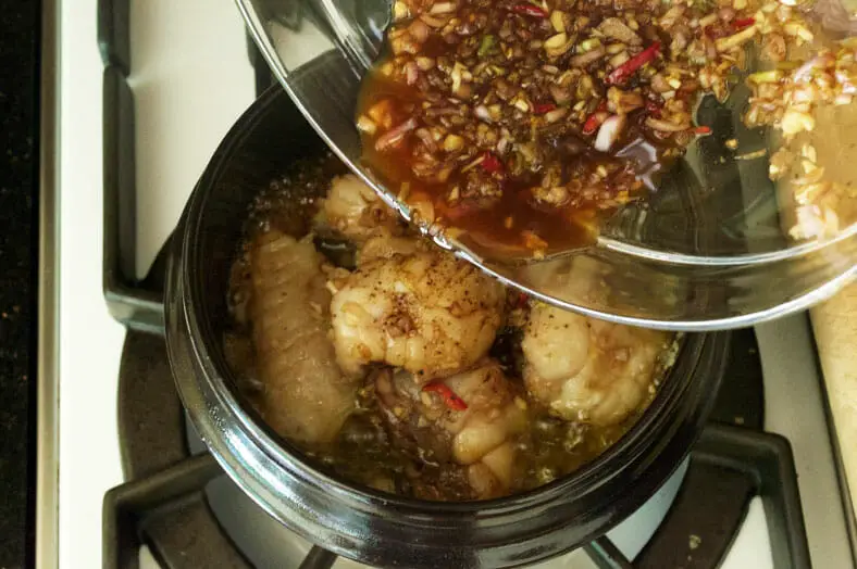 To make Ca Kho To, a Vietnamese caramelized fish stew, you start by cooking lots of garlic and shallots in a clay pot and then layering your marinated fish on top. Then, add coconut water, soy sauce and your left-over fish marinade