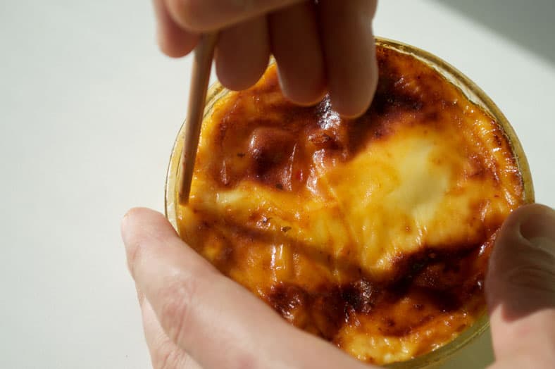 After you bake your stuffed cheese Curacao casserole, called Keshi Yena, you'll want to carefully loosen the cheese from the baking dish by going around the edges. Warning: it's incredibly tempting to bypass this step and just dig right into that bowl of cheesy goodness. No judgement either way!