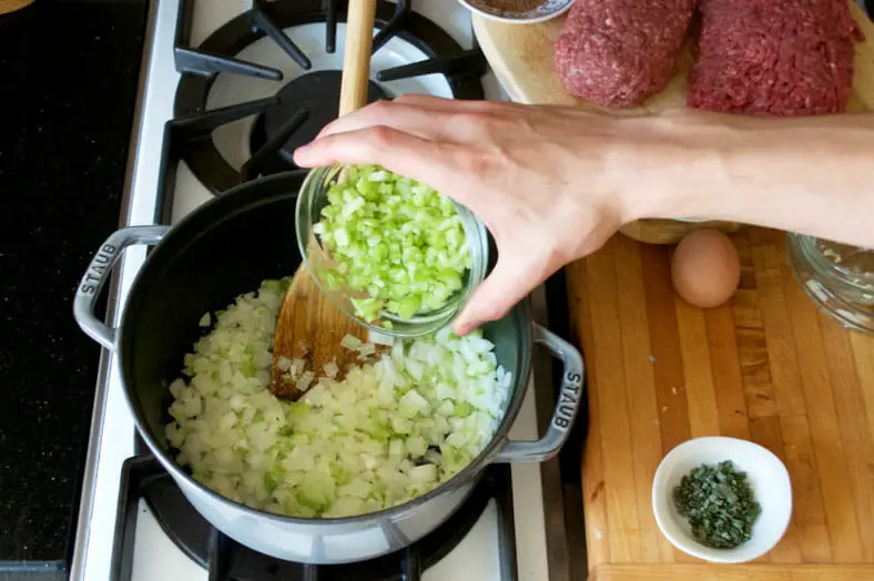 Step 1 to preparing the meat filling for the tourtière (Canadian Christmas meat pie): sauté your garlic, onions and celery together until translucent